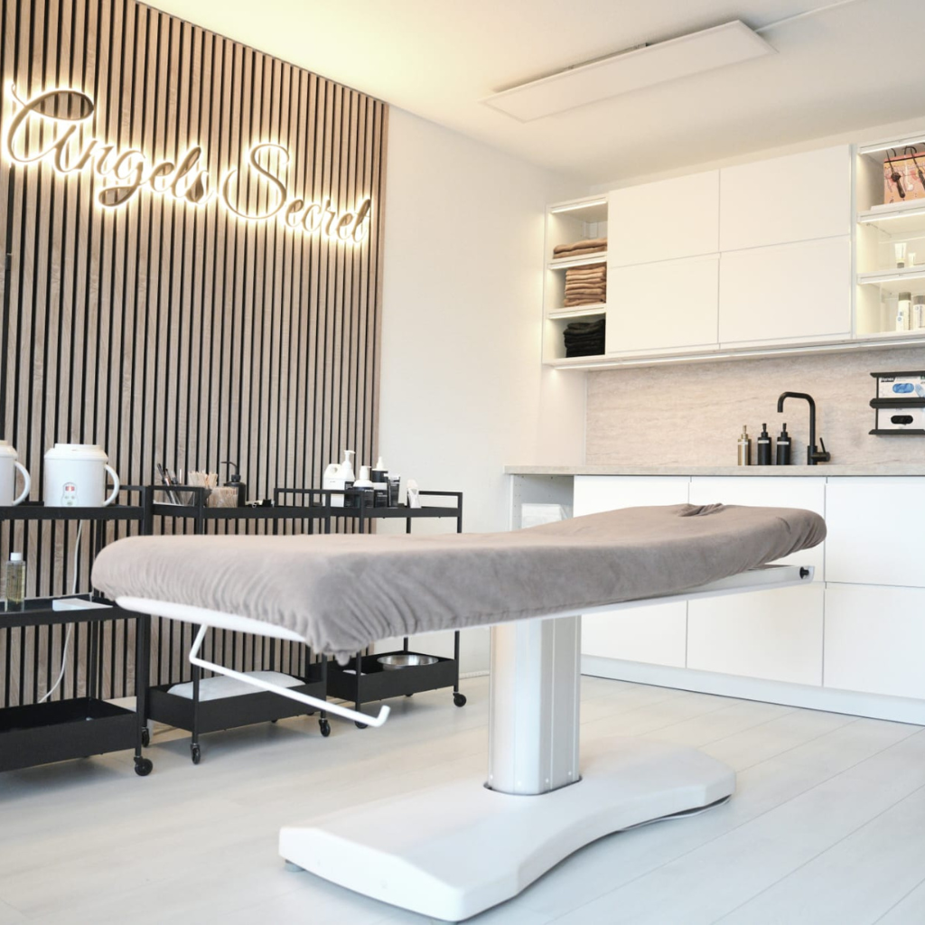 Moderne behandelkamer met behandelstoel en neontekst.